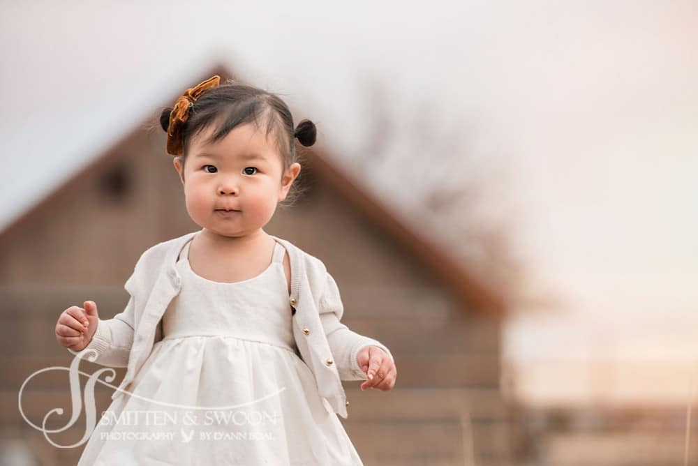 baby girl in beautiful white dress walking