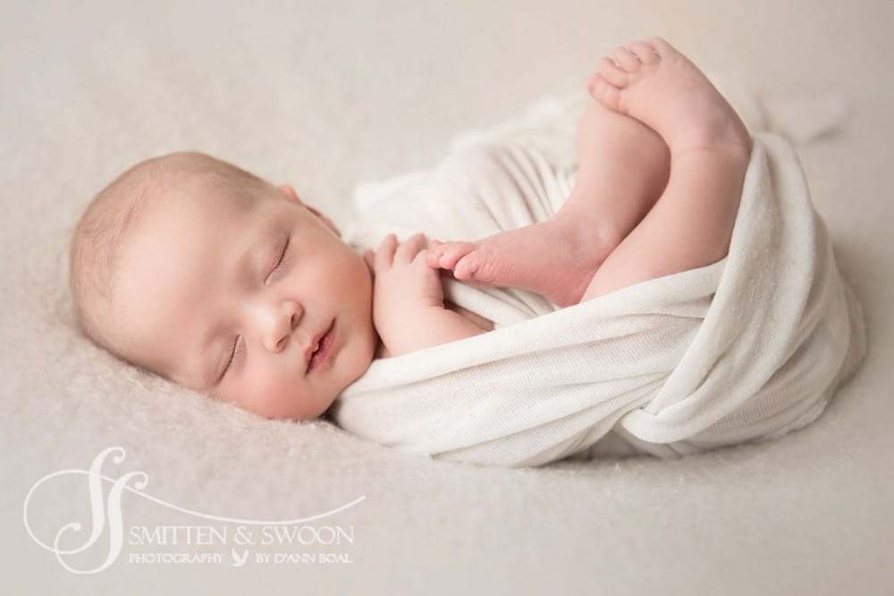 newborn baby swaddled in white laying on her back {newborn photographer boulder}