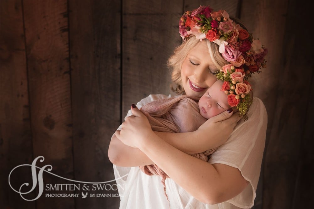 mom holding baby girl wearing flower crowns {boulder newborn photographer}