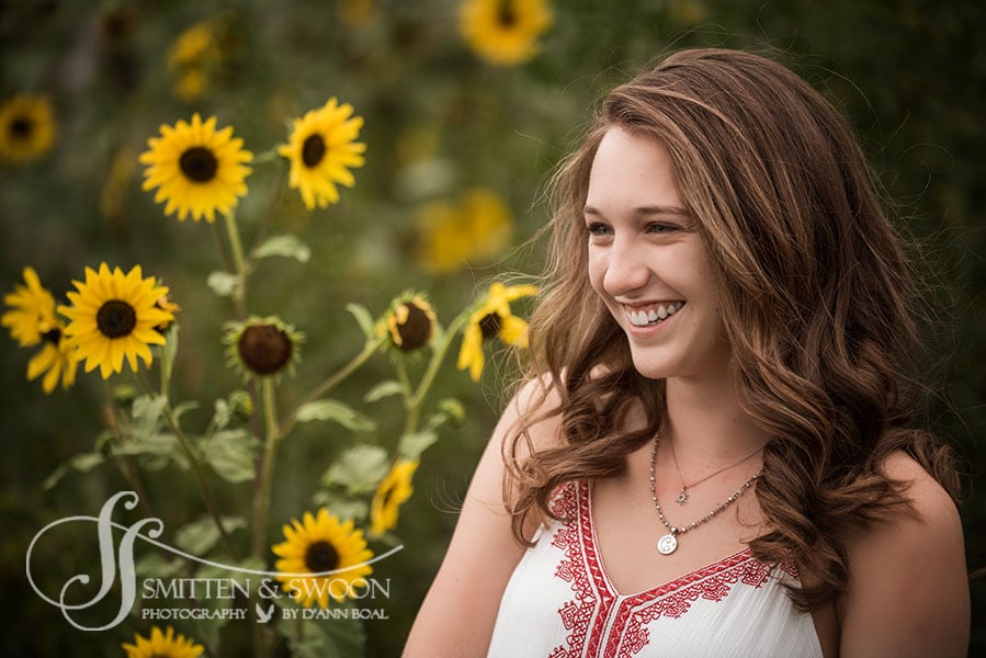 high school senior smiling in field of sunflowers {boulder senior photographer}