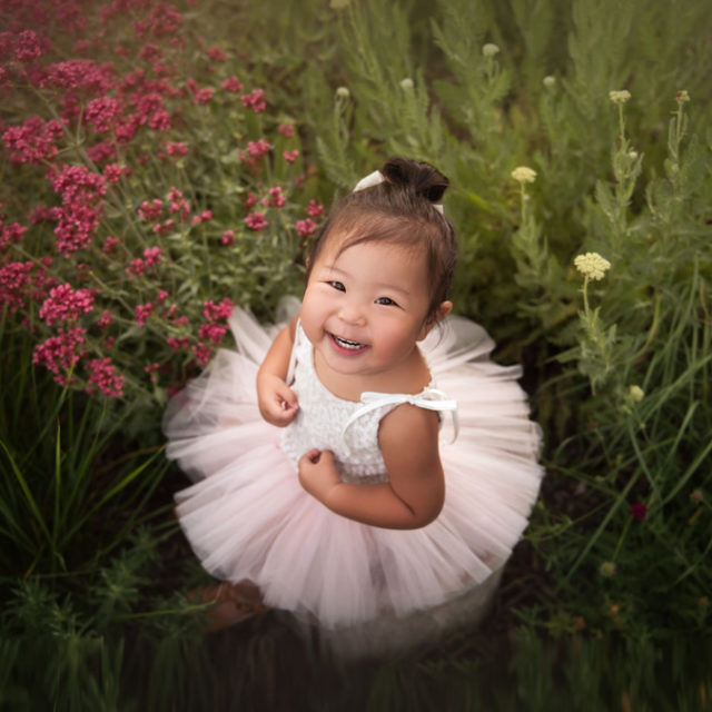 baby girl sitting in garden wearing pink tutu smiling {boulder baby photographer}