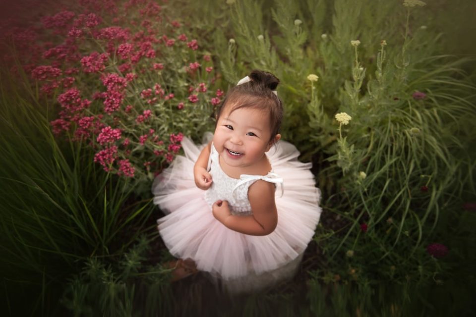 baby girl sitting in garden wearing pink tutu smiling {boulder baby photographer}