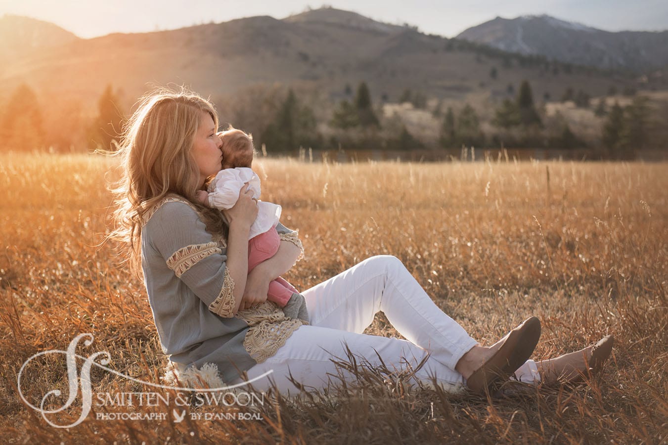 mom and baby girl sitting in golden field boulder photographer