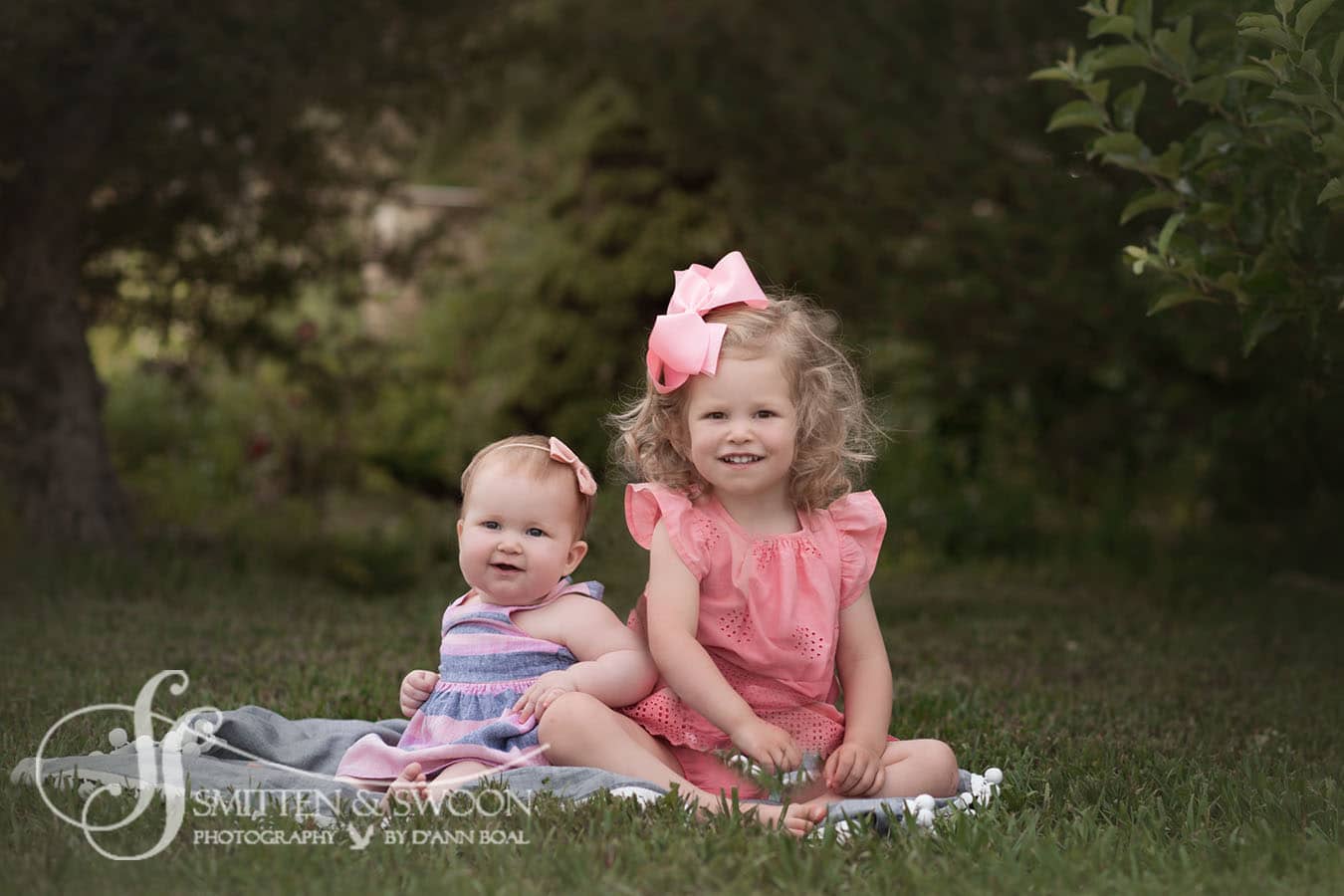 baby girl with big sister sitting in garden boulder photographer