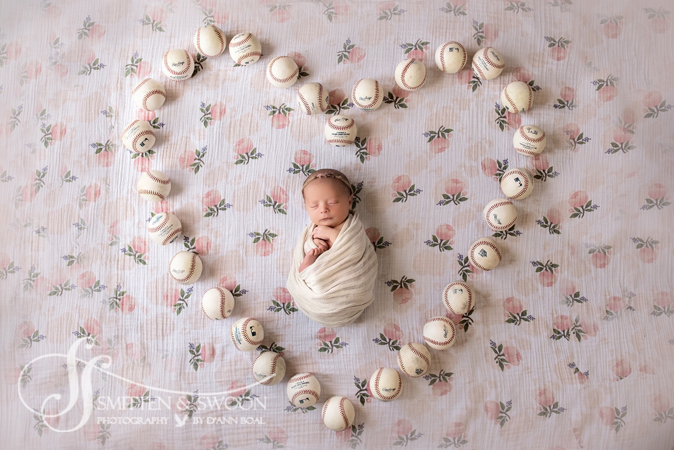 newborn baby girl with baseballs on flower blanket boulder photographer