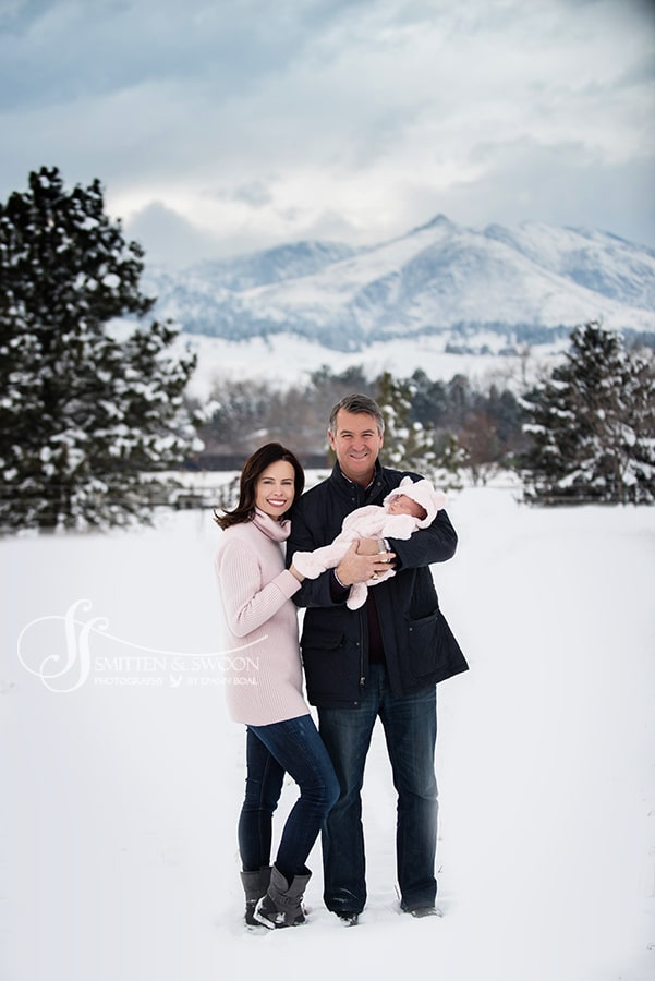 mom dad and baby girl with snowy mountains boulder family photographer