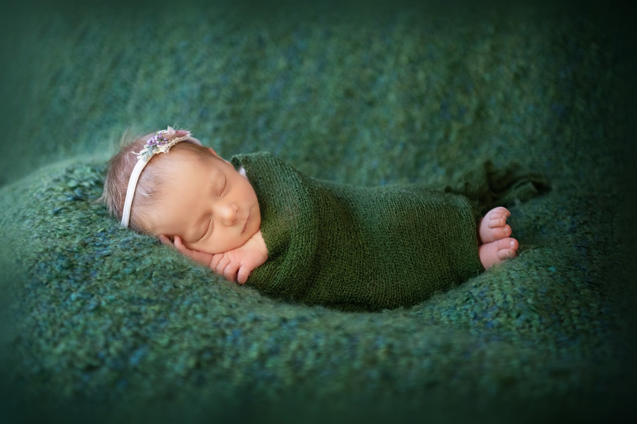 newborn baby girl sleeping with hair pretty on green blanket (boulder photographer)
