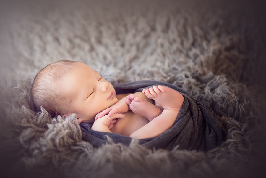 newborn baby boy wrapped in gray sleeping - boulder newborn photographer