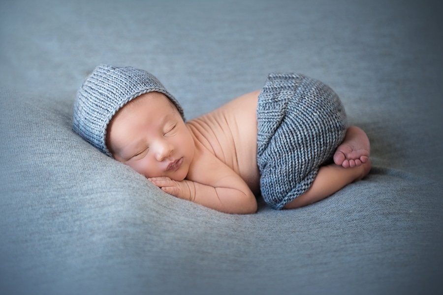 newborn baby boy sleeping elbow to knee pose - boulder newborn photographer