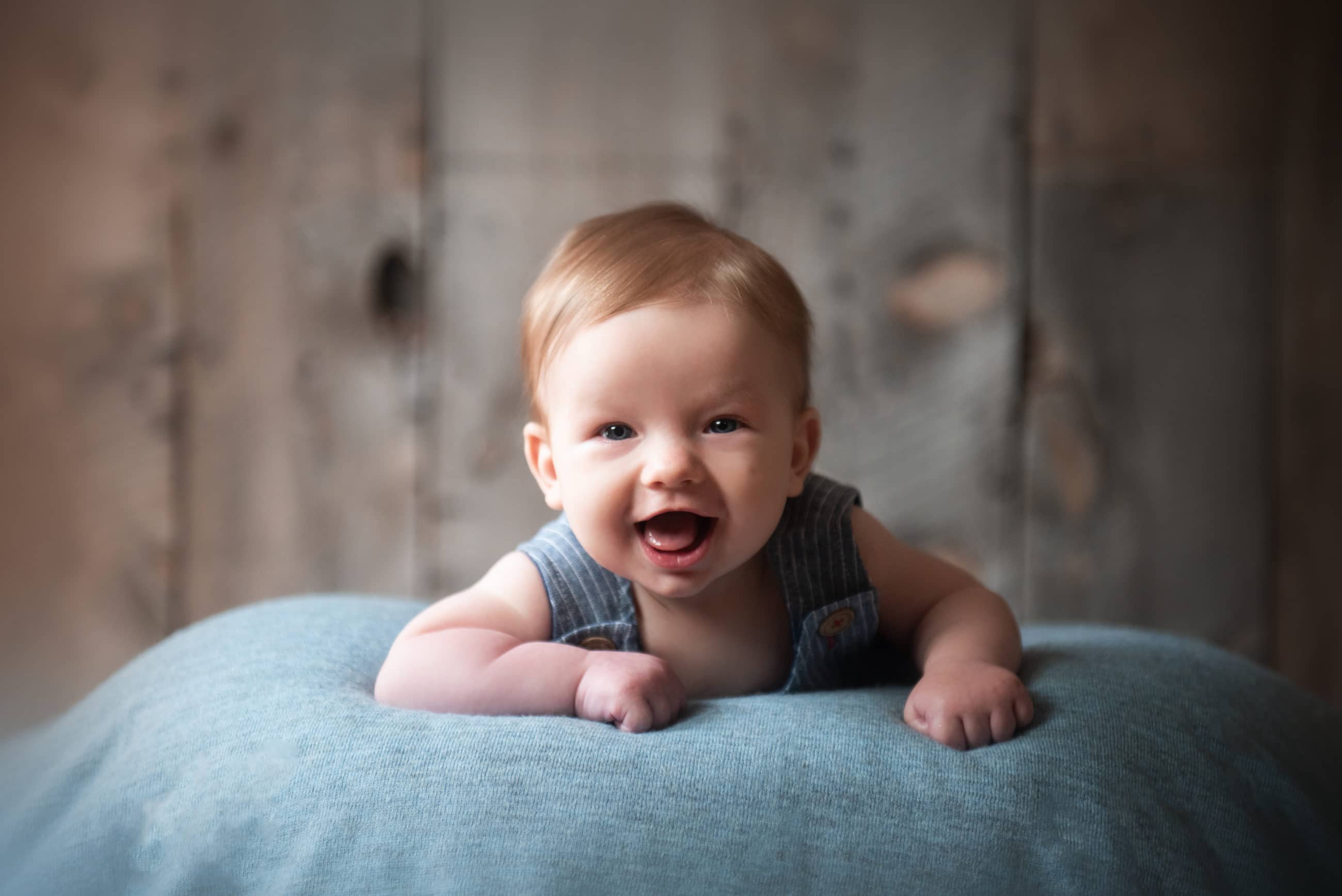 three month old baby boy smiling in blue overalls - boulder photographer