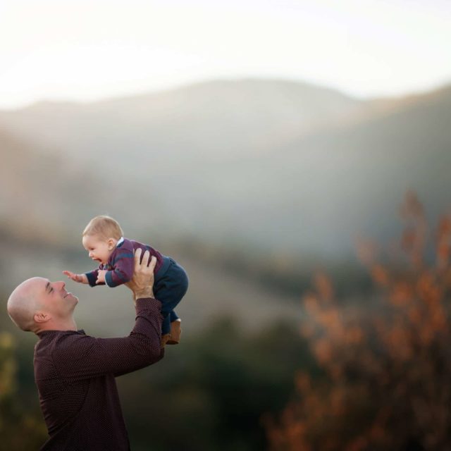 little boy in dad's arms fall foliage and mountain background - boulder photographer
