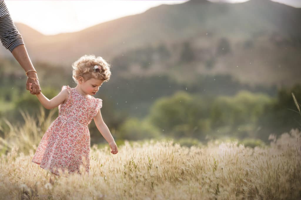 girl holding grandmas hand in golden field with pink dress Boulder photographer