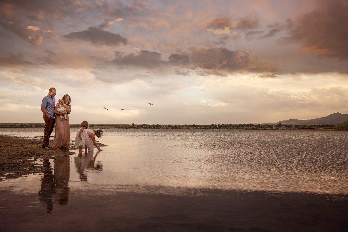 family of five throwing flower petals into a lake at sunset - boulder photographer