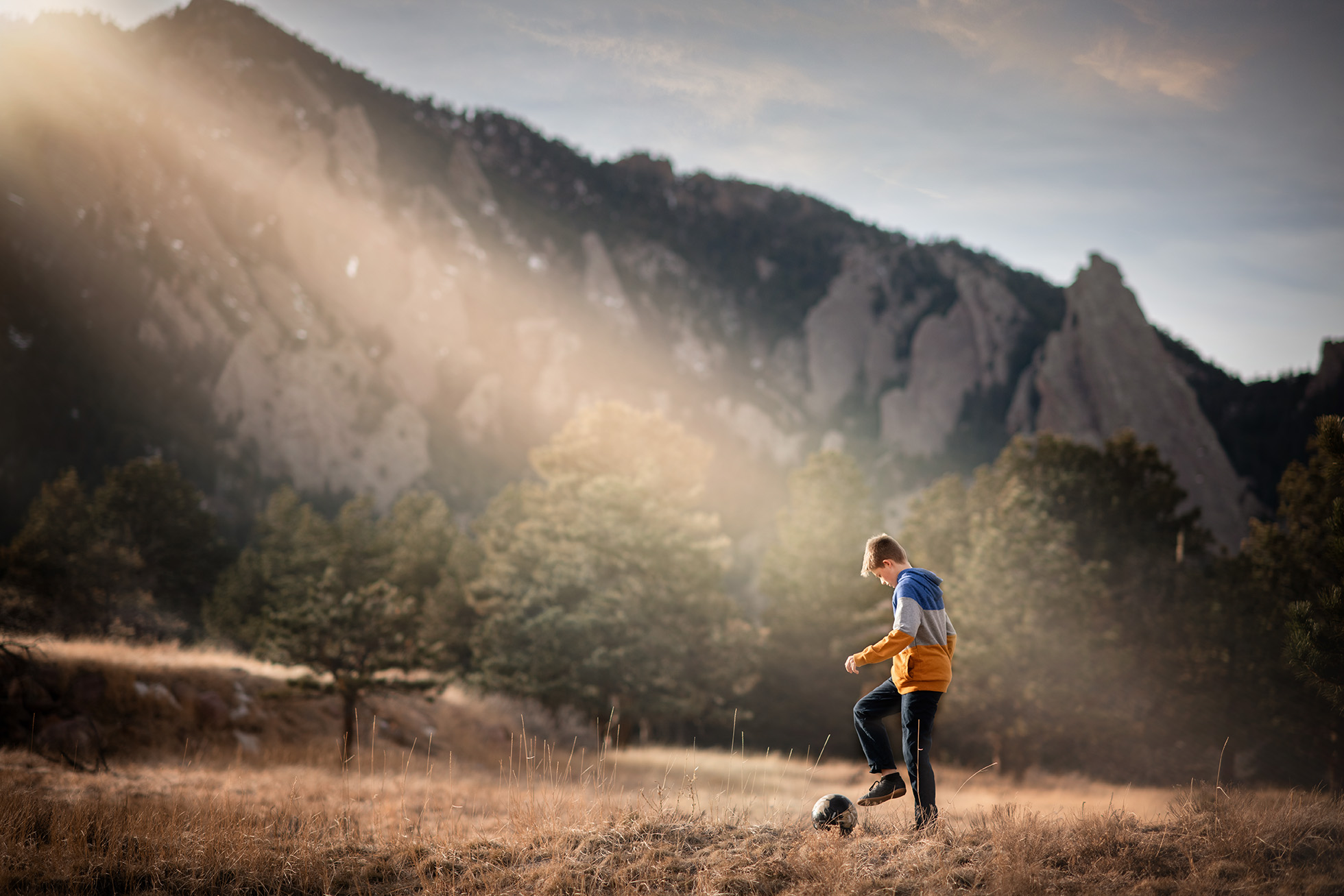 colorado's best photographer - boy playing soccer with mountains behind him