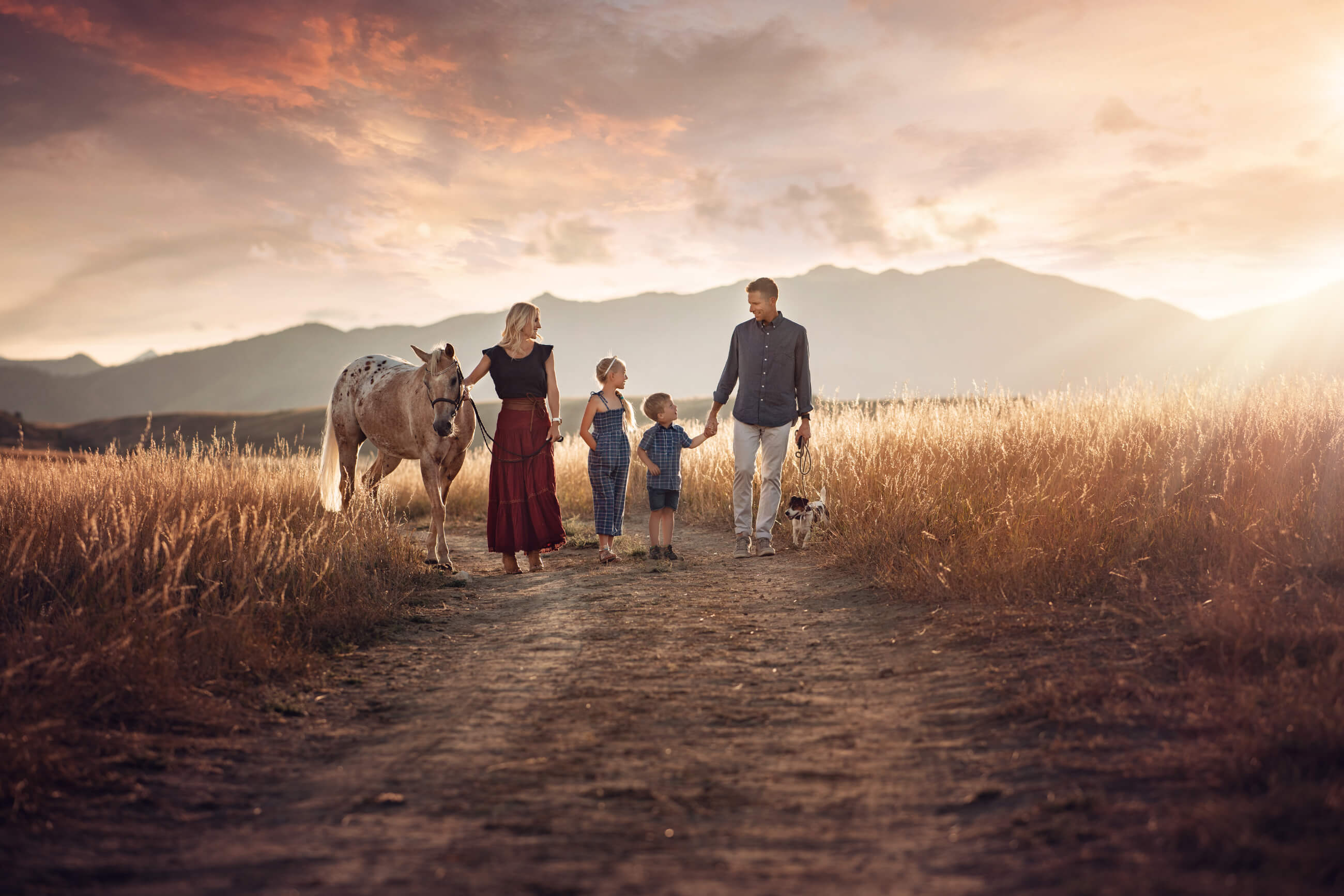 family of four walking with horse mountains in the background boulders best photographer 